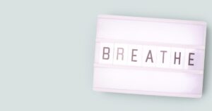 Lightbox displaying the word BREATHE on a pale mint background, white frame and tiles